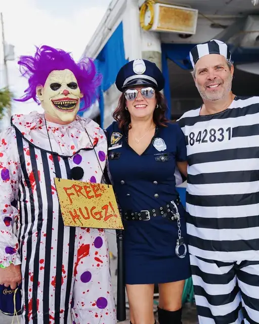 Crawlers dressed as a clown, a police officer and a prisoner at a Halloween bar crawl