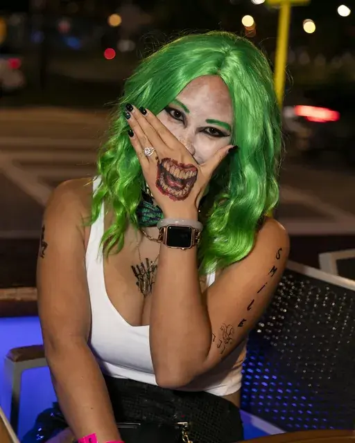 Crawler in a green wig and joker makeup at a Halloween bar crawl